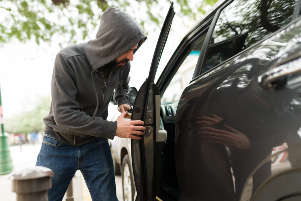 A Man in a Grey Hoodie Holding a Car Door