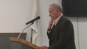 A Man Sanding in Front of a Podium One